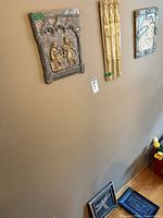 Three plaques hanging on wall showing relative sizes and colours