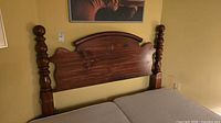 Full view of queen headboard attached to bed frame, shows overall design and two turned posts