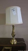 Full view of brass table lamp with shade