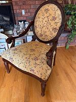 Full view of armchair showing upholstery and wood frame