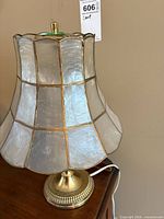 Complete lamp showing base, attached capiz shade and power cord