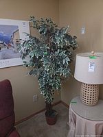 Full view of variegated ficus artificial tree beside furniture