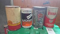 Group shot of four vintage metal cans showing fronts and brands