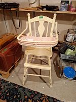Front view of cream wooden high chair with pink tray cushion, removable tray shown propped
