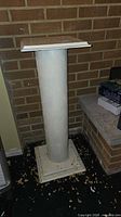 Full view of pedestal against brick wall