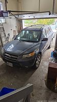 Front three-quarter view of gray Hyundai Santa Fe parked in garage