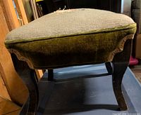 Side view of footstool showing velvet sides and wooden legs
