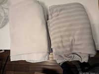 Folded blankets: two shades of grey fleece, one with subtle stripes