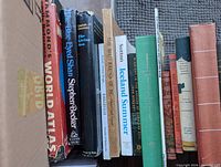 Row of books including Hammond’s World Atlas, The Blue-Eyed Shan, The Living Sea, Bird Fancier, Iceland Summer and others