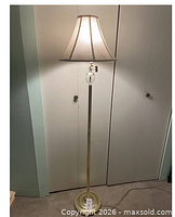 Full view of brass floor lamp with gray shade