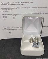 Earrings in open presentation box with appraisal sheet visible