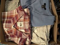 Box with plaid North Face shirt, blue sleeveless top, striped shirt