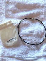 Bracelet and drawstring Pandora pouch displayed on towel