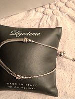 Bracelet on Dyadema pillow showing chain, beads, bolo clasp