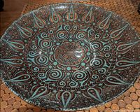 Front view of teal and gold-brown patterned glass bowl