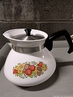 Full view of teapot with lid showing handle and pattern