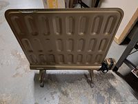 Rear view of smaller gold-tone radiator on casters
