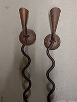Front view of both wrought iron snake sconces showing full length and rust patina