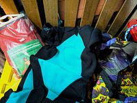 Wetsuit with part of red packaged airbed visible