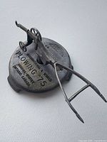 Overall view of cast metal plough on engraved base