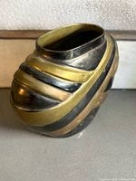 front view showing diagonal tri-colour metal bands