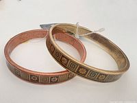 Two bangles side by side showing finishes and enamel pattern