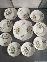 Top view of ten Duchess plates and saucers arranged, showing floral design and gold rims