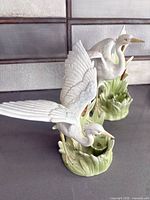 Front perspective of both porcelain heron candleholders