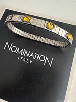Top view of stainless steel stretch bracelet with three yellow stones on Nomination Italy backing