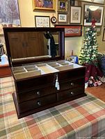 jewelry box open showing mirror, compartments, drawers, key in lock