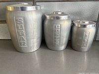 Front view of three aluminum canisters labeled Sugar, Coffee, Tea