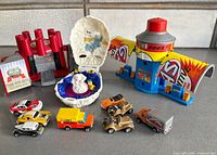 Group shot of three playsets and eight mini vehicles