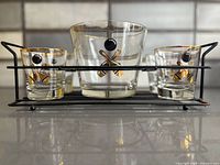 front view of ice bucket, four glasses and caddy showing bowling design