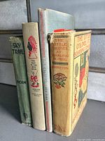 Four upright spines showing titles and authors