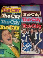 Front view showing multiple The City magazine issues