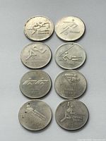 Obverse sides showing sport pictograms for all eight tokens