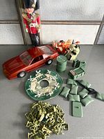 Group shot showing Camaro model, Beefeater doll, Lion King figures, army men accessories, jacks disc