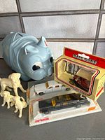 Group shot: blue piggy bank, Majorette cars in blister, Lledo boxed model, three plastic dogs