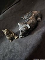 Both bear figurines on black cloth background