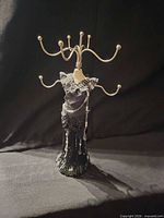Front view of dress-form jewelry holder showing arms and fringe dress