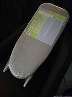 Front view of ironing board still in plastic showing label