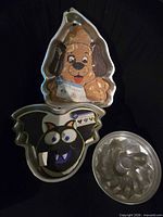 Group shot of three aluminum cake pans: puppy dog, bat, swirl bundt