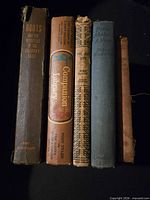 Five hardcovers standing showing spines