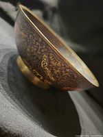 Side view of brass bowl showing exterior minakari bird and floral design