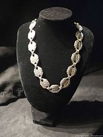 Silver-tone leaf link necklace displayed on bust