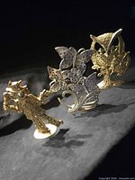 Front view of three metal earring holders