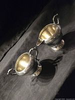 Top view of cream pitcher and sugar bowl showing form and interiors