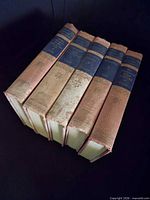 Five matching cloth volumes standing spine-out