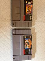 Two SNES cartridges—Nickelodeon Aaahh!!! Real Monsters (top) and Super Adventure Island 2 (bottom)