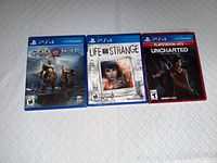 Front view of three PS4 game cases: God of War, Life Is Strange, Uncharted: The Lost Legacy